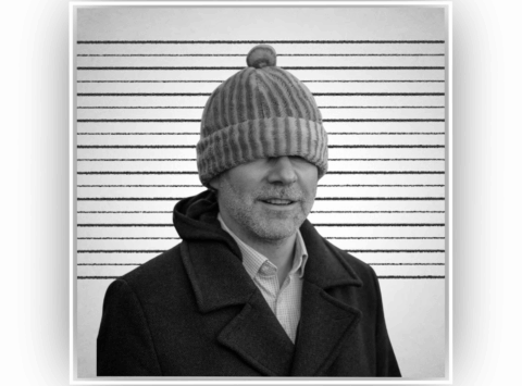 A black and white mug shot of a clown in a silly hat, trying to break everything.